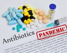 Assorted antibiotics and syringe on document labeled pandemic, illustrating the threat of antibiotic resistance