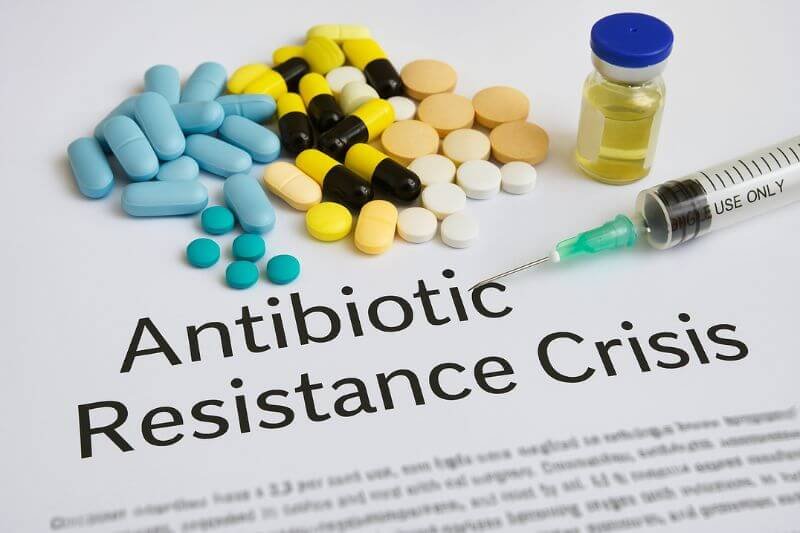 Visual representation of antibiotic resistance crisis with resistant bacteria and medical vials