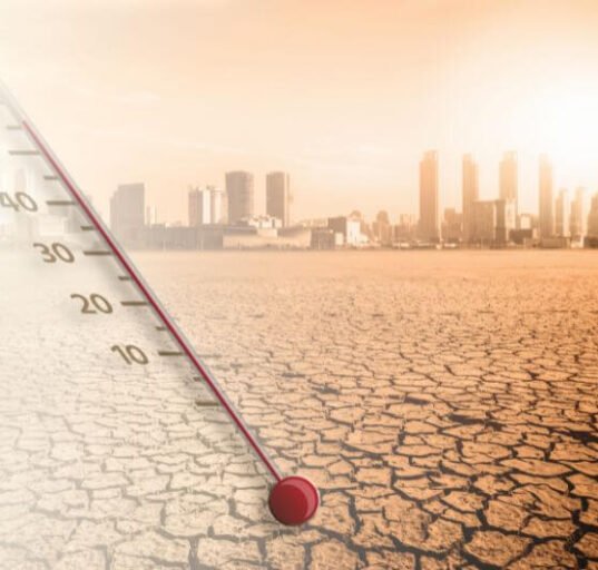 Cracked ground and thermometer illustrating surviving a heatwave in an urban area