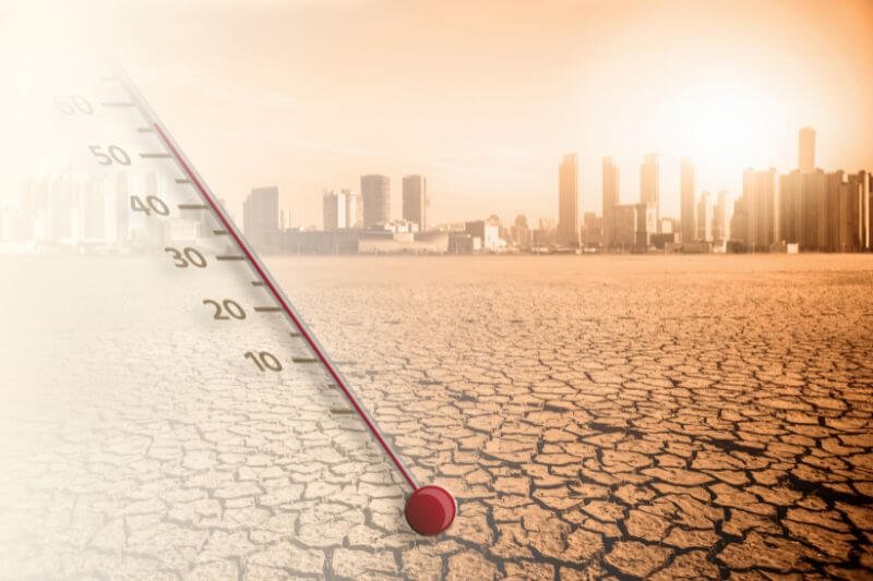 Cracked ground and thermometer illustrating surviving a heatwave in an urban area